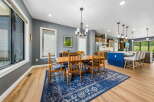 This spacious dining area features a large wooden table with six chairs, perfect for family gatherings.