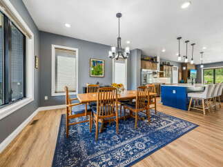 This spacious dining area features a large wooden table with six chairs, perfect for family gatherings.