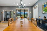 Experience breathtaking mountain views from this elegant dining room, featuring a large wooden table perfect for gatherings.