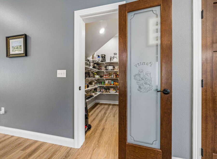 Step into this charming pantry, featuring a frosted glass door with a decorative etched design.