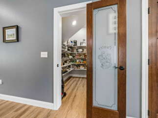 Step into this charming pantry, featuring a frosted glass door with a decorative etched design.