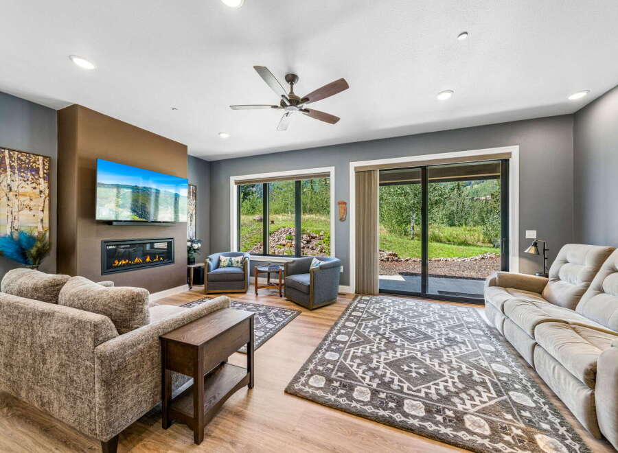 Experience modern living in this spacious living room, featuring a sleek fireplace and a large flat-screen TV perfect for entertainment.