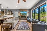 Experience breathtaking mountain views from this stunning living room, featuring a modern fireplace and a large picture window.