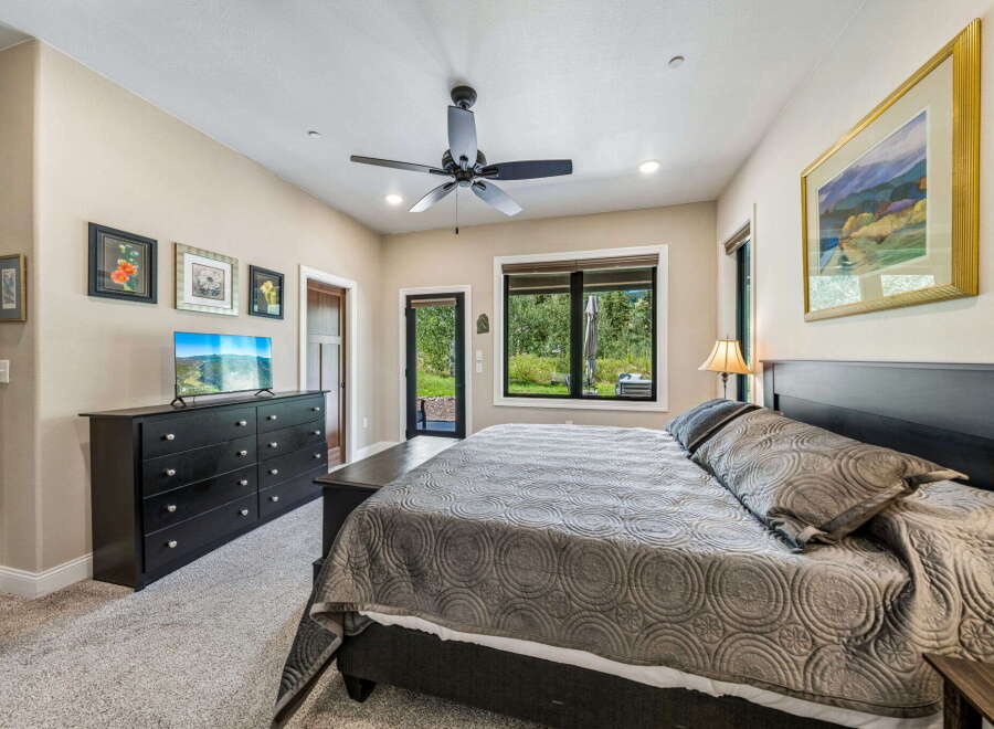 Experience ultimate comfort in this spacious bedroom, featuring a plush king-sized bed adorned with a luxurious quilted comforter.