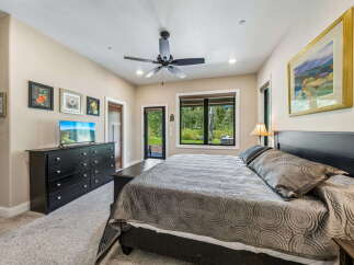 Experience ultimate comfort in this spacious bedroom, featuring a plush king-sized bed adorned with a luxurious quilted comforter.