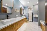 Experience luxury in this modern bathroom featuring a spacious double vanity with vessel sinks and sleek black faucets.