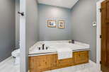 Indulge in relaxation in this luxurious bathroom featuring a spacious soaking tub, perfect for unwinding after a long day.