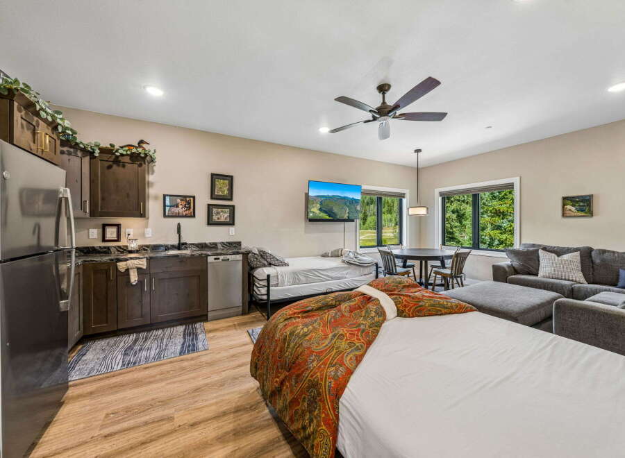 This studio apartment offers a convenient kitchenette with dark wood cabinetry and granite countertops, perfect for preparing meals.