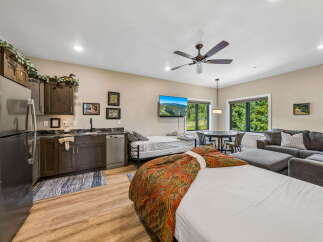This studio apartment offers a convenient kitchenette with dark wood cabinetry and granite countertops, perfect for preparing meals.