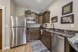 Discover this charming kitchen, featuring a sleek stainless steel refrigerator and a convenient microwave above the sink.