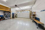 Discover ample storage and organization in this spacious garage, featuring a large overhead storage unit and multiple shelving units.