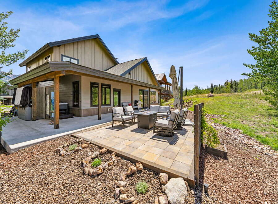 Enjoy outdoor living with this spacious patio featuring comfortable seating and a modern fire pit, perfect for gathering with loved ones.