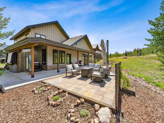 Enjoy outdoor living with this spacious patio featuring comfortable seating and a modern fire pit, perfect for gathering with loved ones.