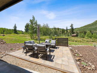Enjoy the stunning mountain views from this beautiful patio, complete with a fire pit and comfortable seating.