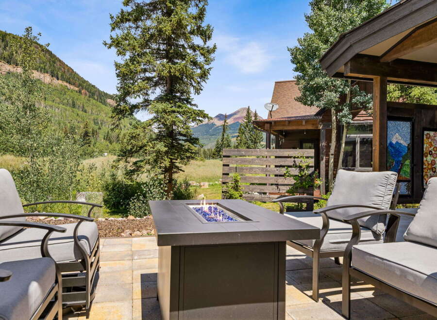 Enjoy breathtaking mountain views from this stunning outdoor living space, complete with a modern fire pit and comfortable seating.