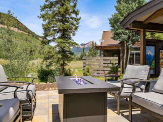 Enjoy breathtaking mountain views from this stunning outdoor living space, complete with a modern fire pit and comfortable seating.