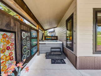 Relax and unwind in this luxurious outdoor living space, featuring a spacious hot tub perfect for soaking.
