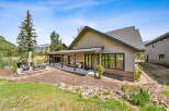 Experience mountain living in this stunning home featuring a spacious covered patio perfect for outdoor entertaining, complete with a grill and comfortable seating.