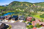 Experience luxury mountain living in this stunning property, nestled beside a serene lake with breathtaking views of ski slopes and lush forests.