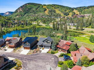 Experience luxury mountain living in this stunning property, nestled beside a serene lake with breathtaking views of ski slopes and lush forests.