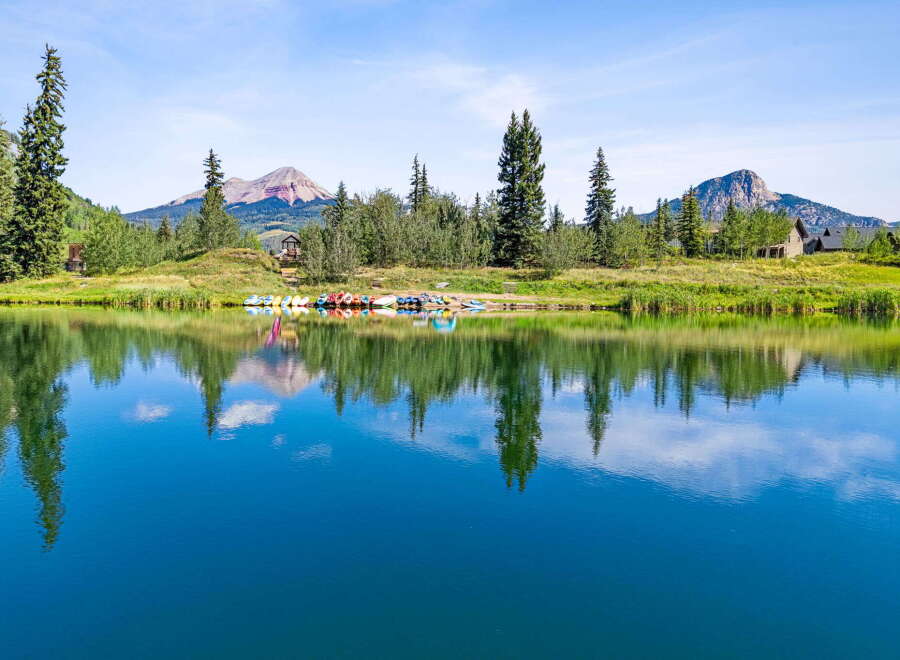 Experience serene lakeside living with this stunning property featuring a calm blue lake perfect for kayaking and paddle boating.