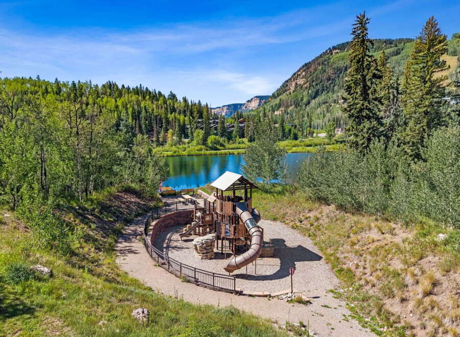 Discover a family-friendly paradise with this stunning playground overlooking a serene lake, perfect for outdoor recreation.