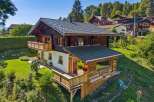 Experience alpine living in this charming wooden chalet, nestled on a lush green hillside with stunning mountain views.