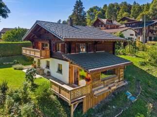 Experience alpine living in this charming wooden chalet, nestled on a lush green hillside with stunning mountain views.