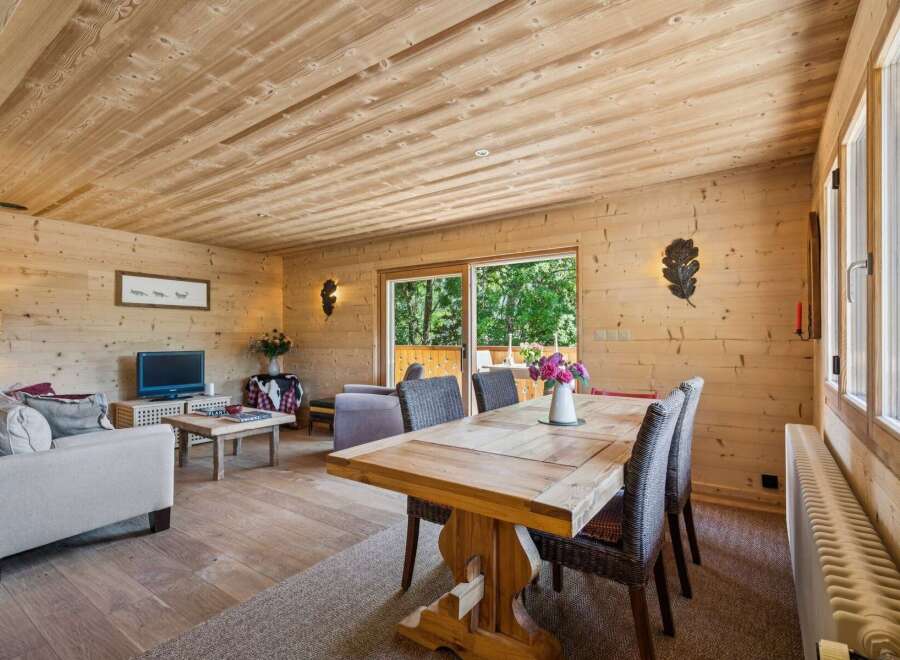 Experience rustic charm in this beautifully appointed living and dining area, featuring warm wood paneling throughout.