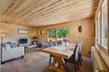 Experience rustic charm in this beautifully appointed living and dining area, featuring warm wood paneling throughout.