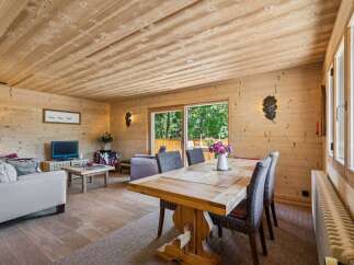 Experience rustic charm in this beautifully appointed living and dining area, featuring warm wood paneling throughout.