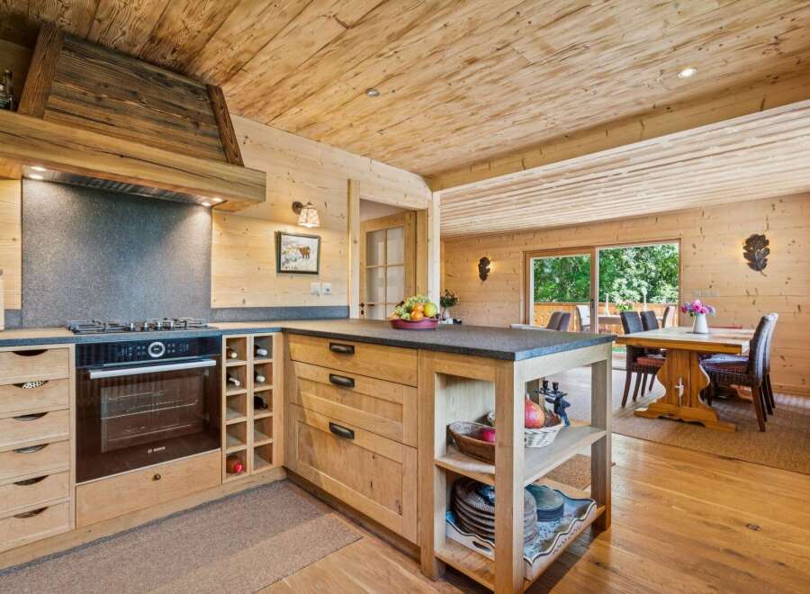 Experience rustic charm in this beautifully appointed log cabin kitchen, featuring a modern Bosch oven and gas stovetop integrated into custom wooden cabinetry.