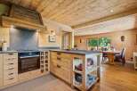 Experience rustic charm in this beautifully appointed log cabin kitchen, featuring a modern Bosch oven and gas stovetop integrated into custom wooden cabinetry.