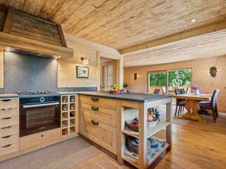 Experience rustic charm in this beautifully appointed log cabin kitchen, featuring a modern Bosch oven and gas stovetop integrated into custom wooden cabinetry.