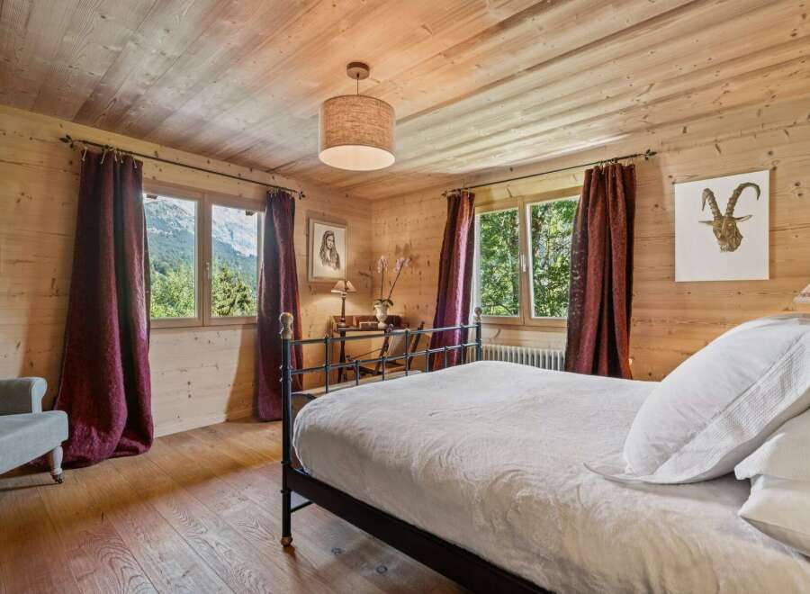 Experience rustic charm in this beautifully appointed bedroom, featuring warm wood paneling and a cozy ambiance.