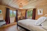 Experience rustic charm in this beautifully appointed bedroom, featuring warm wood paneling and a cozy ambiance.