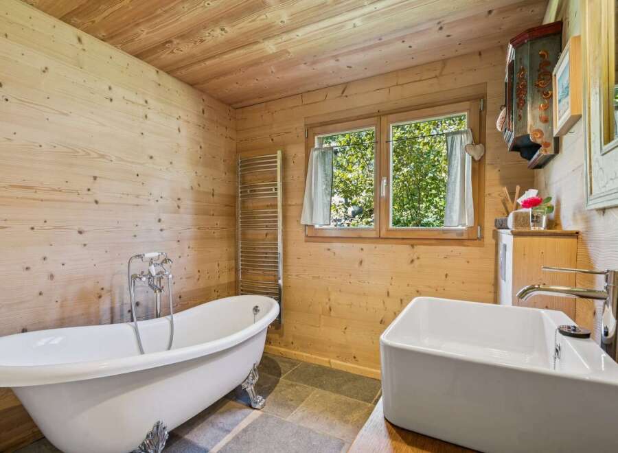 Experience rustic charm in this beautifully appointed bathroom, featuring a freestanding clawfoot tub perfect for a relaxing soak.