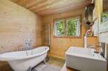 Experience rustic charm in this beautifully appointed bathroom, featuring a freestanding clawfoot tub perfect for a relaxing soak.