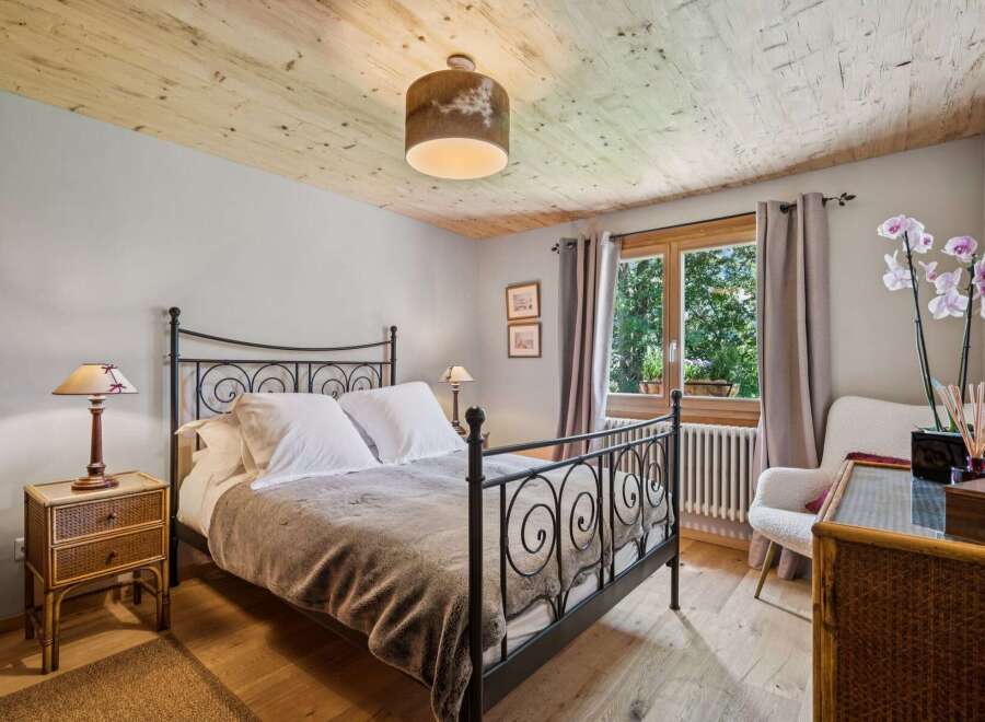 Experience rustic charm in this inviting bedroom, featuring a cozy metal-frame bed adorned with crisp white linens and a plush throw.