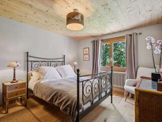 Experience rustic charm in this inviting bedroom, featuring a cozy metal-frame bed adorned with crisp white linens and a plush throw.