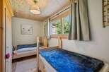 This charming bedroom features two cozy wooden beds, perfect for a restful night's sleep.