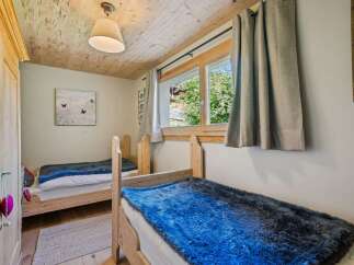 This charming bedroom features two cozy wooden beds, perfect for a restful night's sleep.