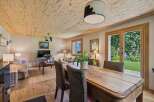 Experience rustic charm in this inviting living and dining area, featuring a natural wood-paneled ceiling and warm hardwood floors.