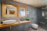 Experience rustic luxury in this modern bathroom featuring a floating live-edge wood vanity with a vessel sink.