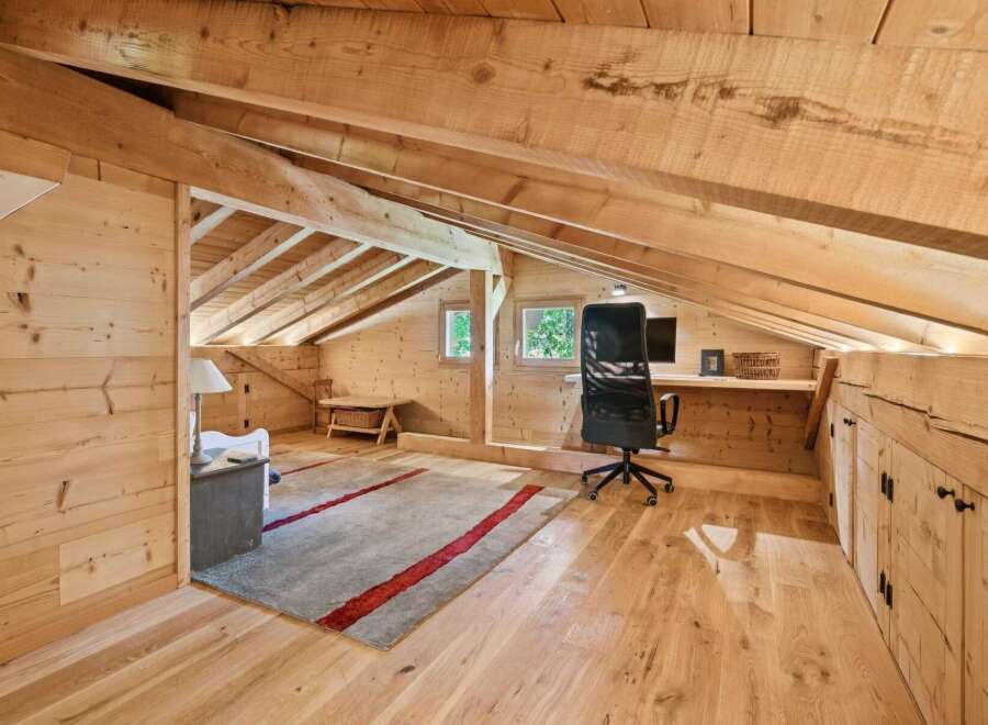Discover this charming attic workspace, bathed in natural light and featuring a rustic wooden design.