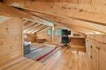 Discover this charming attic workspace, bathed in natural light and featuring a rustic wooden design.