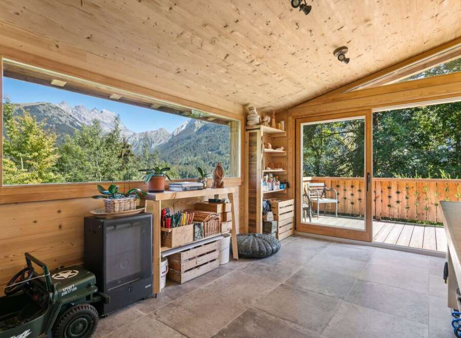 Experience breathtaking mountain views from this charming wooden room, featuring a large panoramic window that frames the majestic scenery.