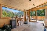 Experience breathtaking mountain views from this charming wooden room, featuring a large panoramic window that frames the majestic scenery.