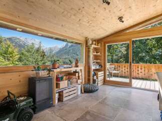Experience breathtaking mountain views from this charming wooden room, featuring a large panoramic window that frames the majestic scenery.