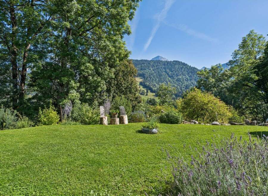 Experience breathtaking mountain views from this serene property, featuring a lush green lawn perfect for relaxation and outdoor activities.